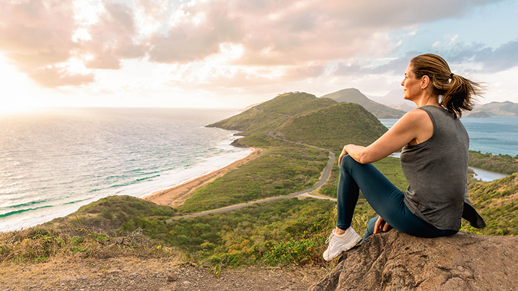 woman sitting on rock looking at ocean